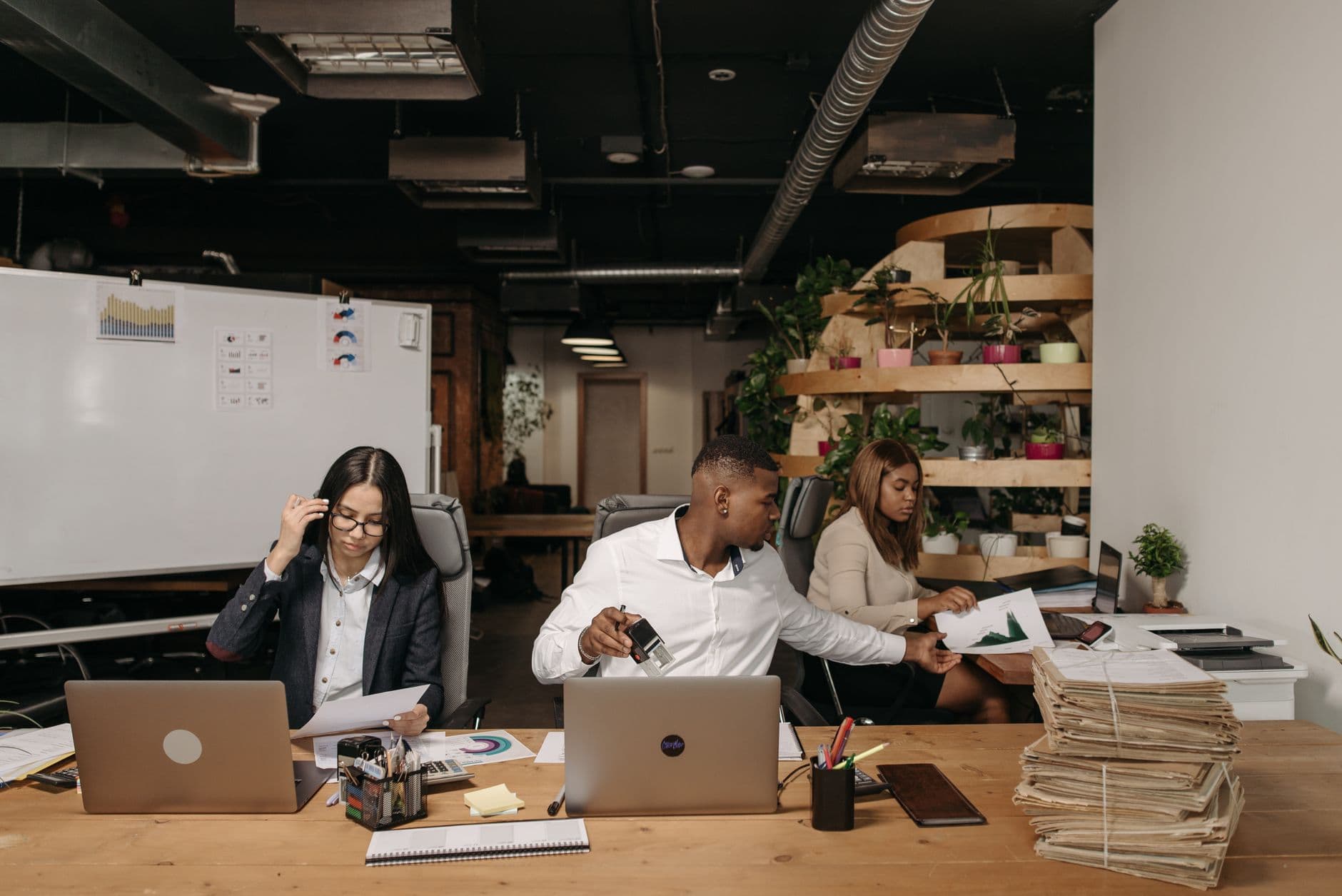 Accounting team members collaborating around a laptop in a modern office