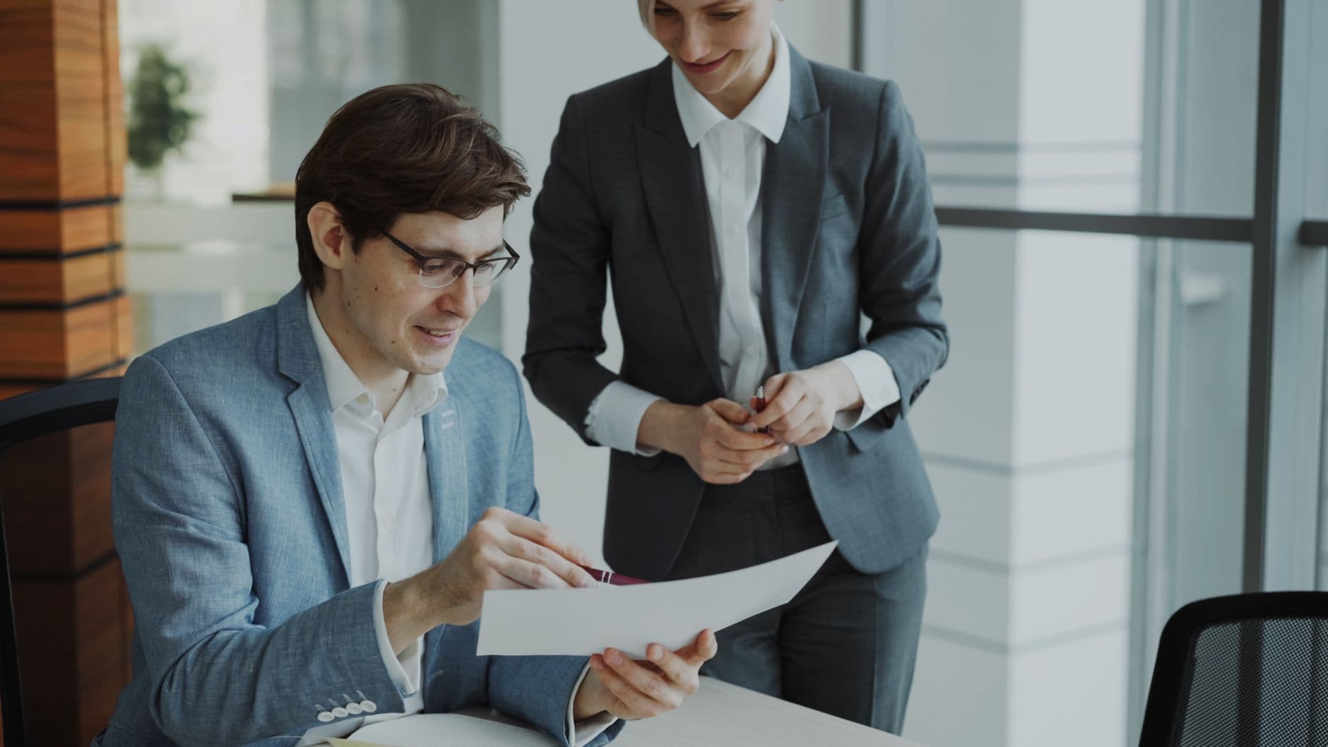 Property manager reviewing rental portfolio documents and a laptop at a desk