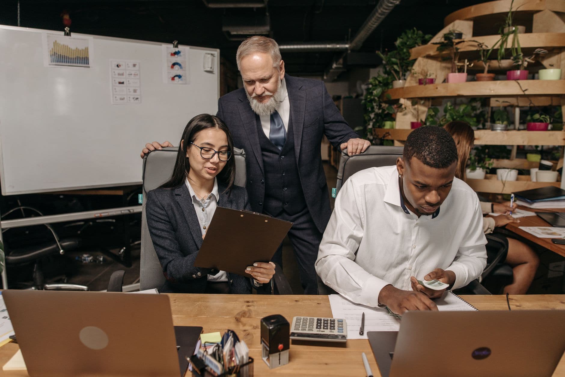 Accounting team collaborating around a laptop on client reporting