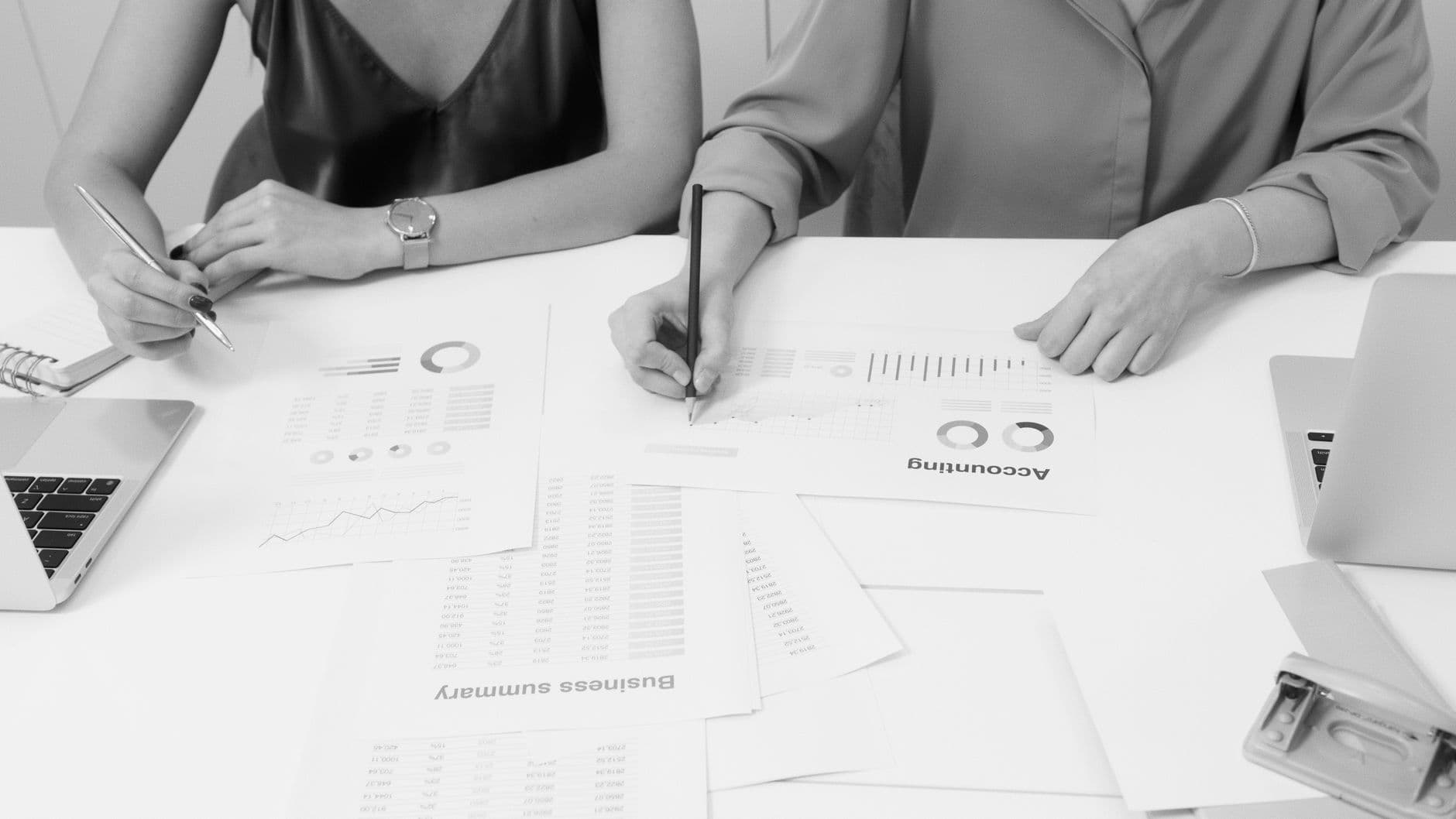 Accountant reviewing financial reports with a small business owner at a desk