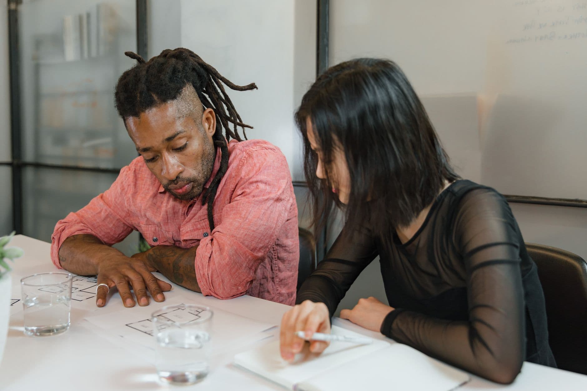 Two business partners discussing long-term planning documents at a desk